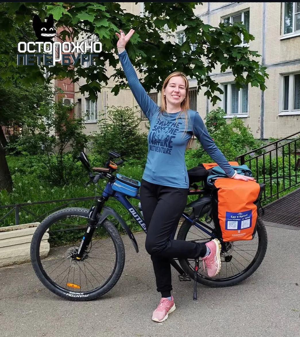 Женщина начала путешествие длиной около 12 000 км из Санкт‑Петербурга в Шанхай. За месяц она доехала до Тюмени, в пути переживает непогоду, иногда получает помощь от подписчиков и продолжает движение, несмотря на травму.