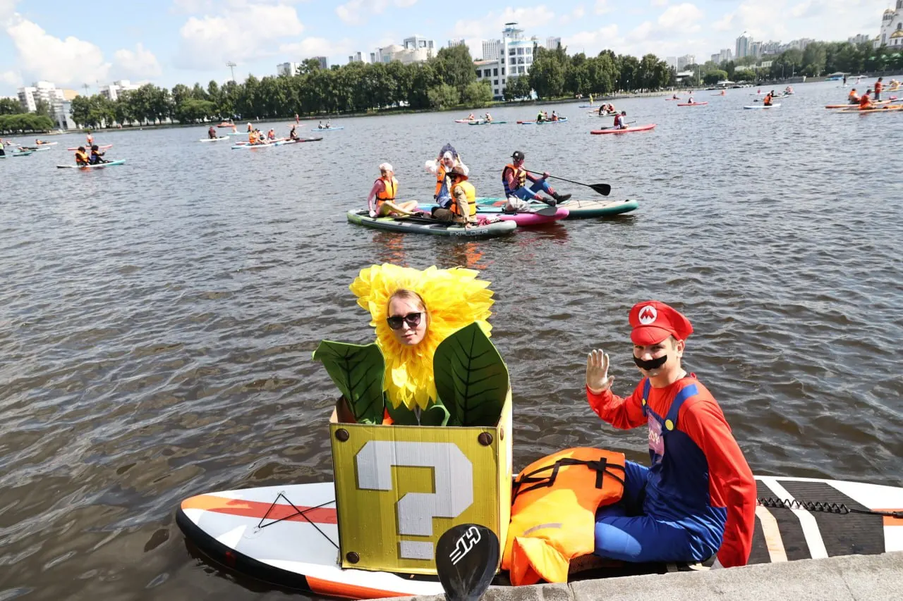 Сотни участников в ярких костюмах вышли на городской пруд в рамках E1 SUP FEST — фестиваля сапбординга, собравшего более тысячи человек из разных городов России.