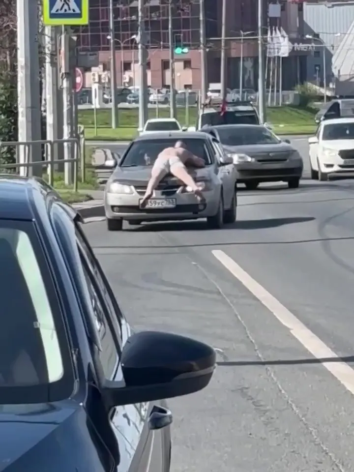 У кольца около автовокзала прохожие увидели человека на капоте движущегося автомобиля. Очевидцы выдвигают версии от жары и опьянения до проигрыша пари.