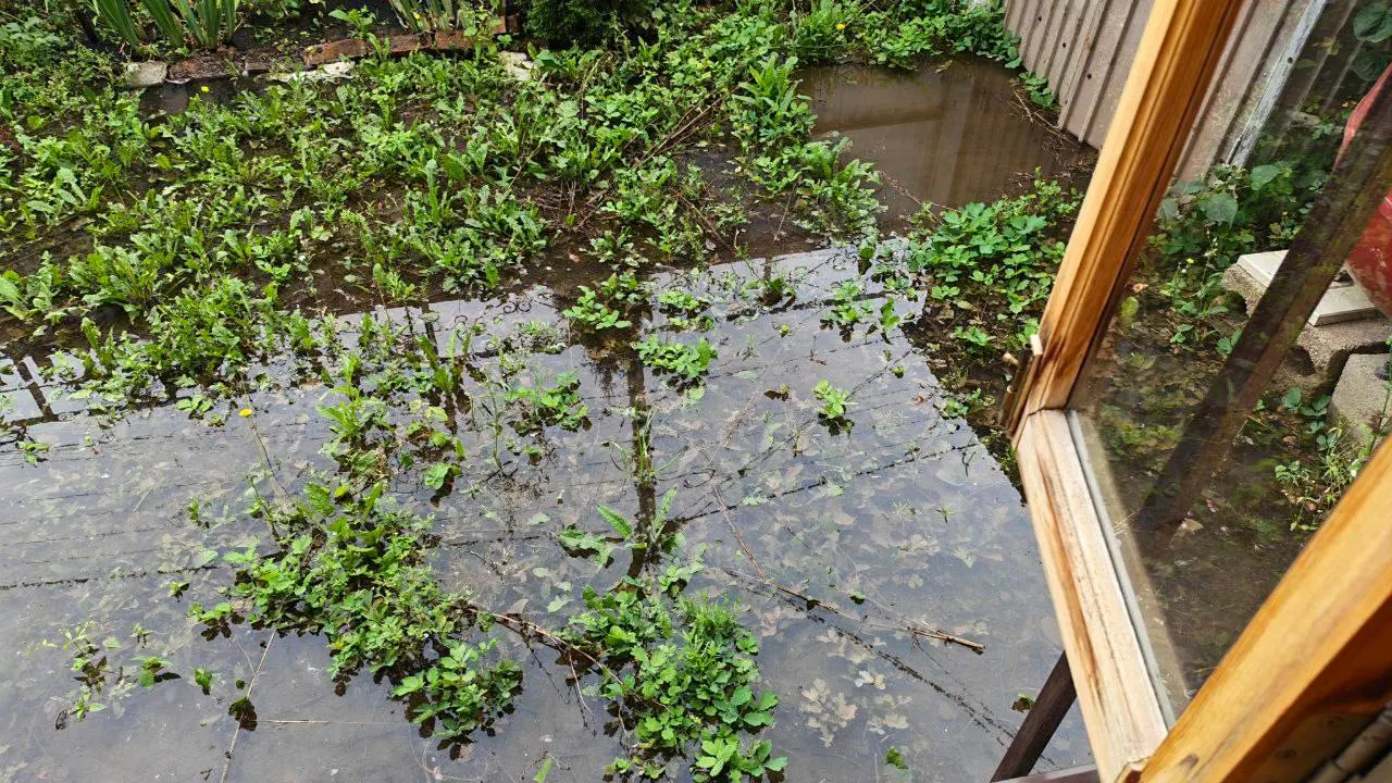 Из‑за прорыва холодного водоснабжения дворы улицы Металлистов затоплены; грунт под опорой ЛЭП становится нестабилен, что создаёт риск падения линии. Местные жители пытаются откачивать воду.